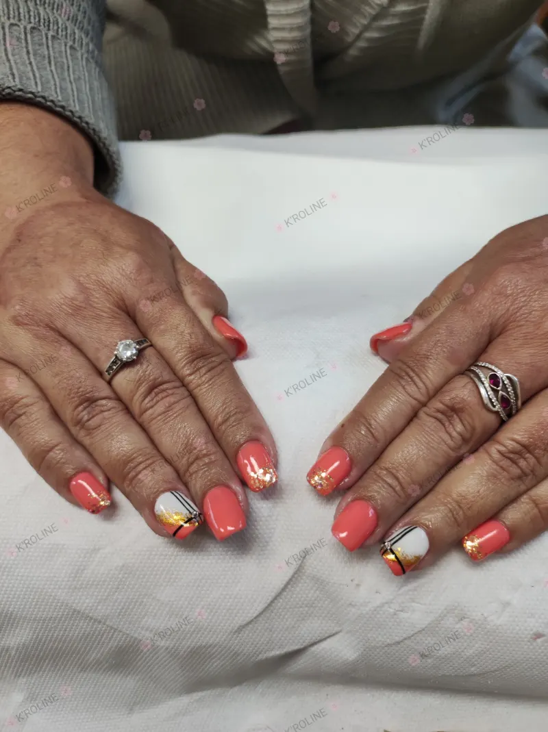 Ongles corail aux pointes pailletées d'or, un ongle blanc rayé