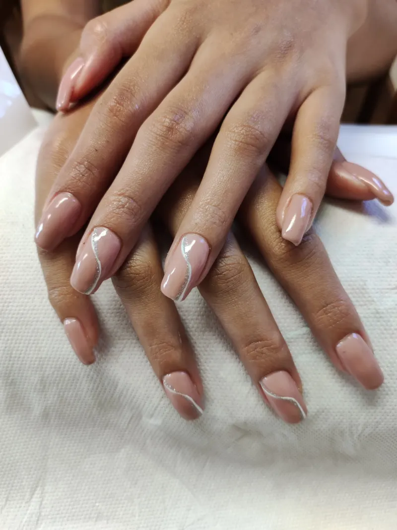Ongles nude avec un trait argenté en vague
