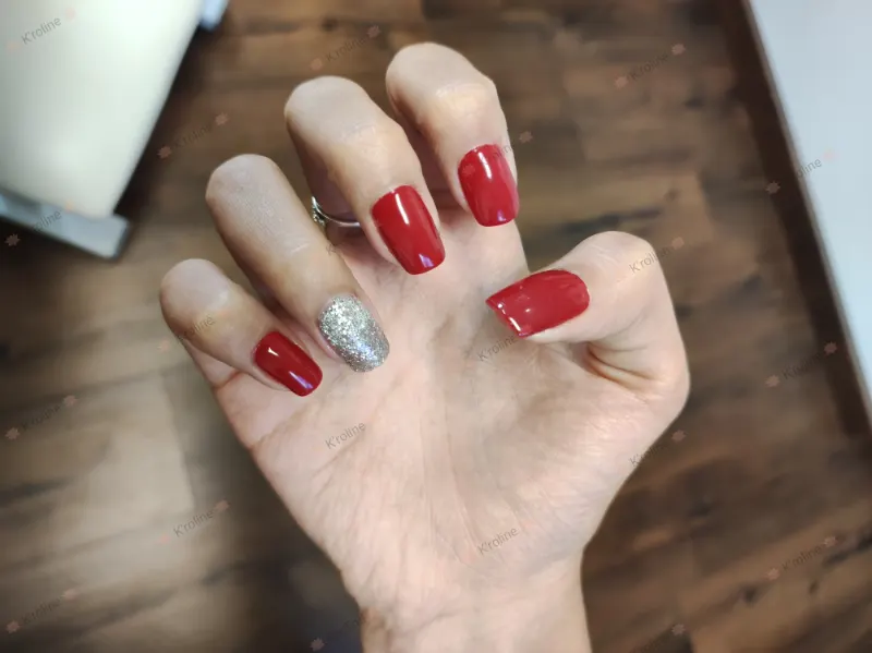 Ongles rouges, un ongle couvert de paillettes argent